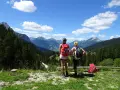 Två kvinnor med ryggsäckar njuter av utsikten över bergen under en vandring i Tyskland.