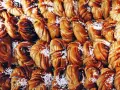 En stor bricka med gyllenbruna kanelbullar, en svensk specialitet, toppade med pärlsocker.