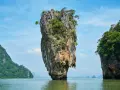 James Bond Island, en ikonisk kalkstensklippa som reser sig ur havet, omgiven av frodiga öar under en klarblå himmel.