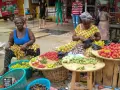 Kvinnor säljer färska grönsaker och frukter på en marknad. En del av deras resa till Ghana.