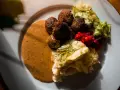 Klassiska svenska rätter: köttbullar med krämig sås, potatismos, lingon och pressgurka.
