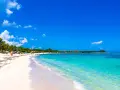 Vacker strand med turkost vatten och vita moln. Trots den idylliska vyn, kan Playa del Carmen vara farligt.