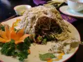 En vacker vietnamesisk maträtt med krispig rispapperstäckt sallad, dekorerad med morotsblomma och örter.