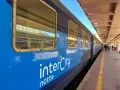 Blått InterCity-tåg står vid perrongen, redo för en resa till Sicilien.