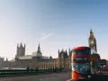 En röd dubbeldäckare passerar Big Ben och Houses of Parliament. En perfekt dag för en **turista i London**.