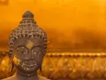 Buddhas ansikte med guldfolierester, en påminnelse om lugn under regnperioden i Asien.