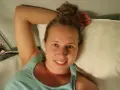 En kvinna ler i en tågkupé, redo för en god natts sömn på resan.