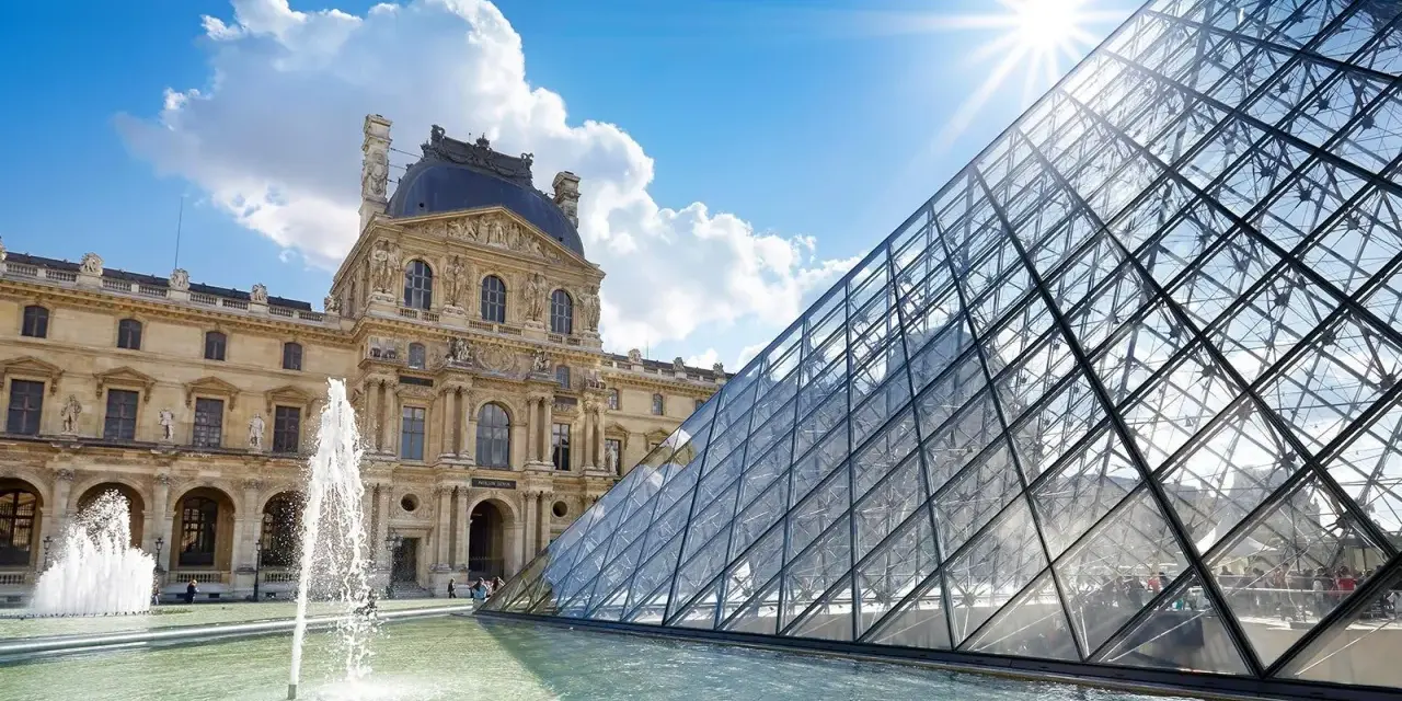 Louvren, ett berömt konstmuseum i Paris, med sin ikoniska glaspyramid och fontäner i förgrunden under en solig himmel.