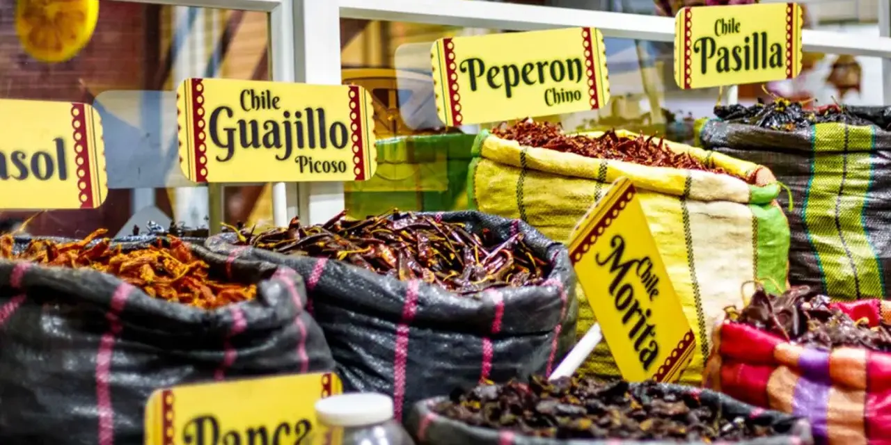 Säckar med torkade chilisorter som Guajillo, Pasilla och Morita. En härlig syn av autentisk colombia mat, redo att ge smak åt rätter.