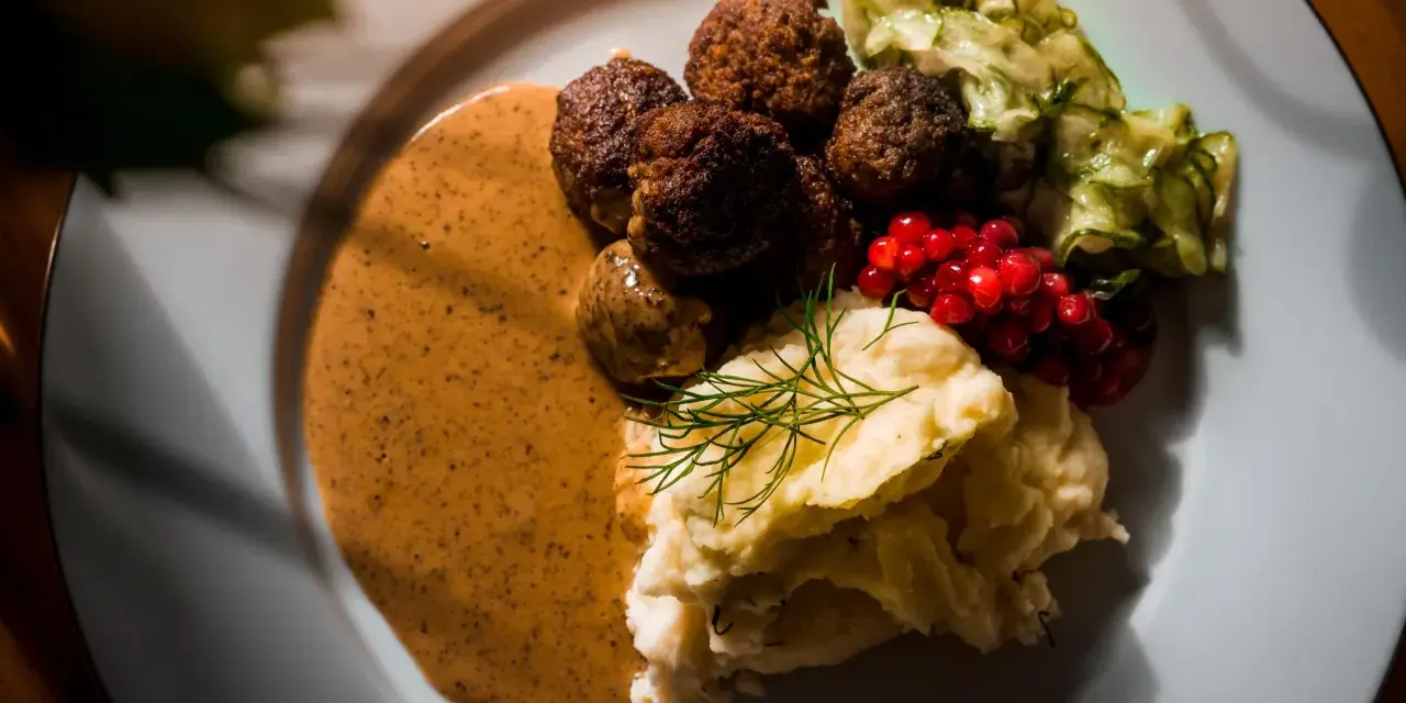 Klassiska svenska rätter: köttbullar med krämig sås, potatismos, lingon och pressgurka.