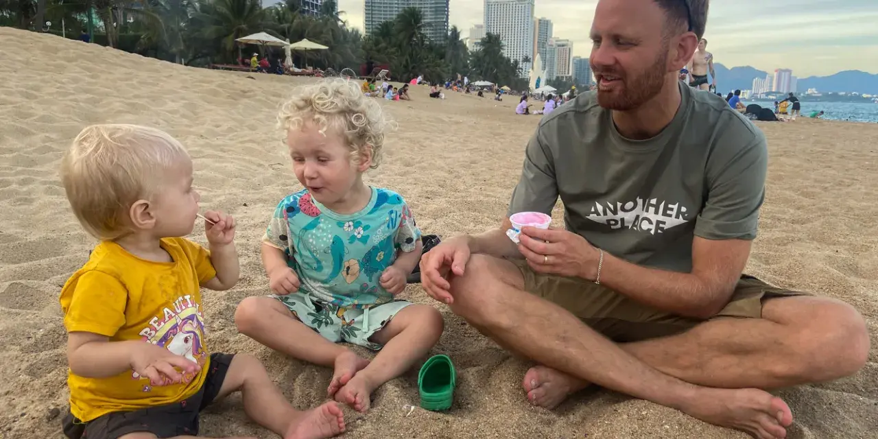 En familj njuter av glass på stranden. Undrar du vad kostar det att åka till Thailand 2 veckor?