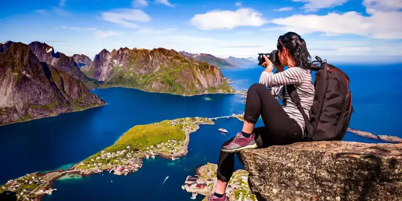 Fotograf fångar den dramatiska skönheten i Lofoten. Här är några **Lofoten tips** för din resa: vandra till Reinebringen för denna vy!