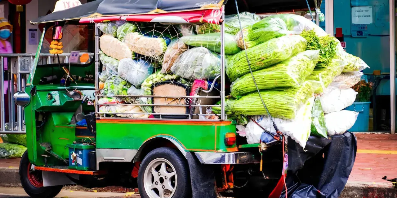 Grön tuk tuk thai lastad med grönsaker, redo för leverans.