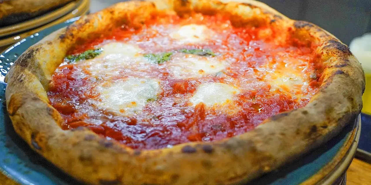 En härlig pizza florens med bubblig kant, röd tomatsås och smält mozzarella. Perfekt för en mysig kväll.