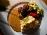 Klassiska svenska rätter: köttbullar med krämig sås, potatismos, lingon och pressgurka.