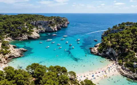 Vacker vik med turkost vatten, båtar och solande människor. En idyllisk plats där spanien vinter temperatur lockar besökare.