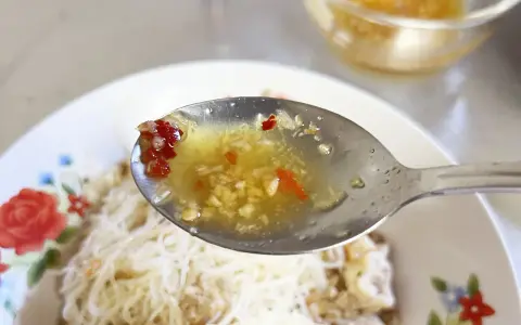 En sked med kryddig sås med vitlök och chili, redo att förhöja smaken på kambodjansk mat.