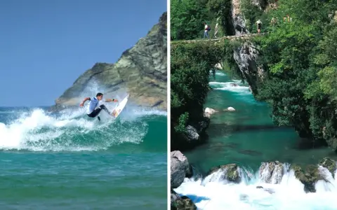 Surfare på en våg vid en klippa och en turkos flod med en stenbro och vandrare. Vacker natur i Spanien.