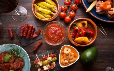 En härlig samling portugal mat: charkuterier, räkor, oliver, paprika och tomater, perfekt för en tapasbuffé.