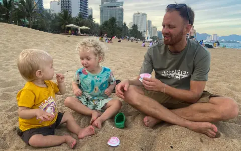 En familj njuter av glass på stranden. Undrar du vad kostar det att åka till Thailand 2 veckor?