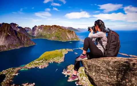 Fotograf fångar den dramatiska skönheten i Lofoten. Här är några **Lofoten tips** för din resa: vandra till Reinebringen för denna vy!