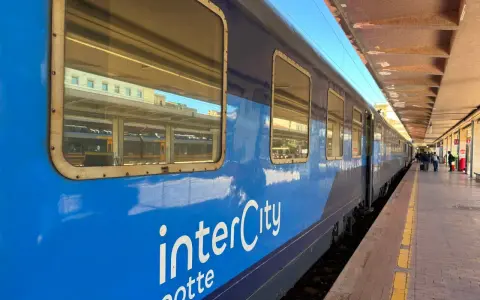 Blått InterCity-tåg står vid perrongen, redo för en resa till Sicilien.