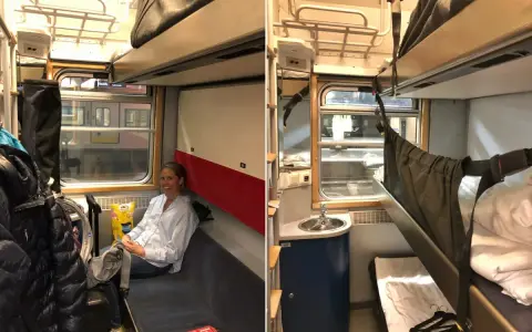 En kvinna sitter i en liggvagn SJ. Bredvid henne finns bagage och en bädd.