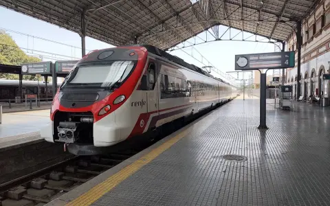 Ett modernt rött och vitt Renfe-tåg står redo på perrongen. Kanske är det dags för ett tåg till Spanien?