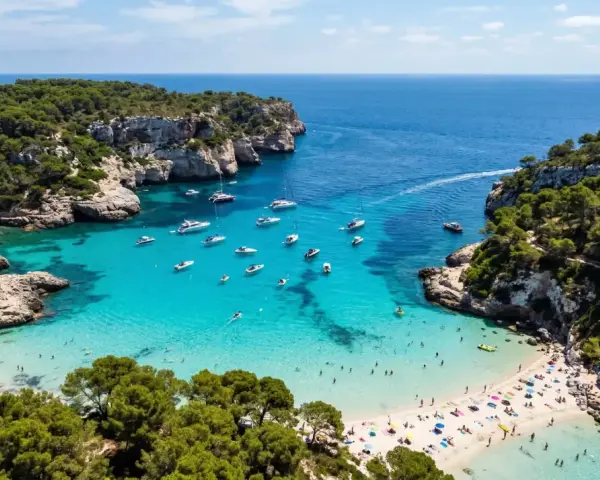 Vacker vik med turkost vatten, båtar och solande människor. En idyllisk plats där spanien vinter temperatur lockar besökare.