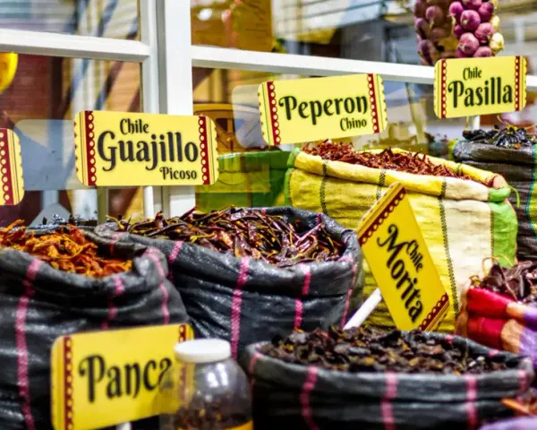 Säckar med torkade chilisorter som Guajillo, Pasilla och Morita. En härlig syn av autentisk colombia mat, redo att ge smak åt rätter.