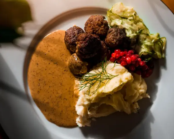 Klassiska svenska rätter: köttbullar med krämig sås, potatismos, lingon och pressgurka.