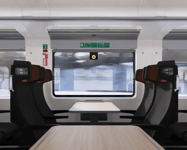 Interiör i ett modernt tåg med bekväma säten och fällbara bord. Nya nattåg erbjuder en bekväm resa genom det snöiga landskapet.