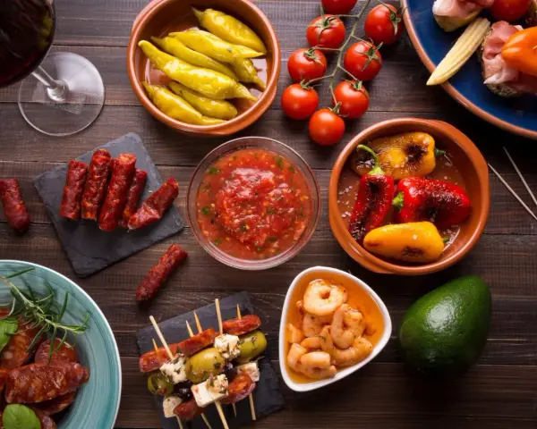 En härlig samling portugal mat: charkuterier, räkor, oliver, paprika och tomater, perfekt för en tapasbuffé.