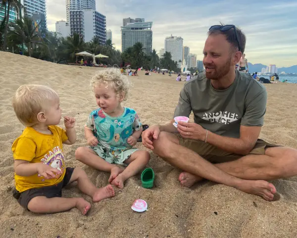 En familj njuter av glass på stranden. Undrar du vad kostar det att åka till Thailand 2 veckor?