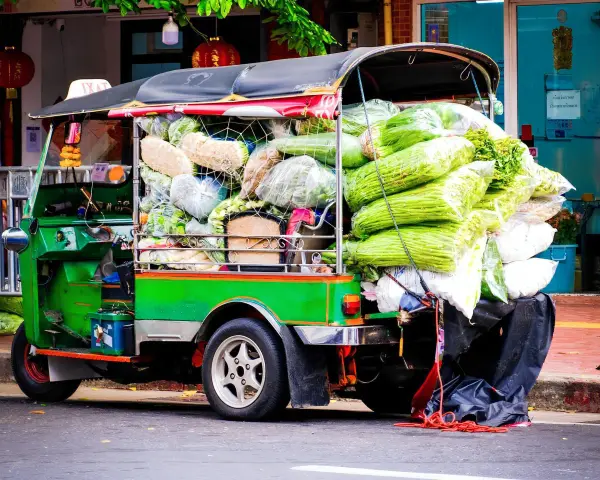 Grön tuk tuk thai lastad med grönsaker, redo för leverans.