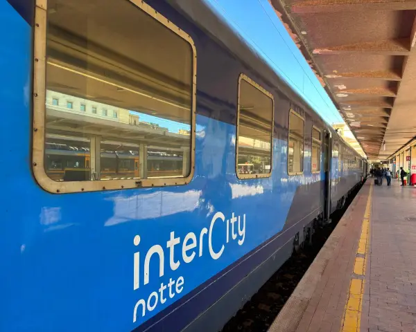 Blått InterCity-tåg står vid perrongen, redo för en resa till Sicilien.