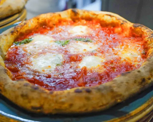 En härlig pizza florens med bubblig kant, röd tomatsås och smält mozzarella. Perfekt för en mysig kväll.