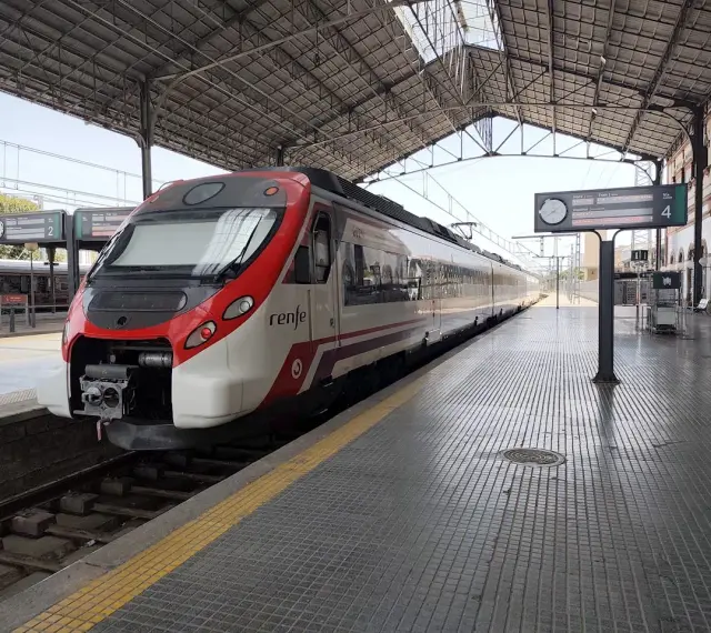 Ett modernt rött och vitt Renfe-tåg står redo på perrongen. Kanske är det dags för ett tåg till Spanien?
