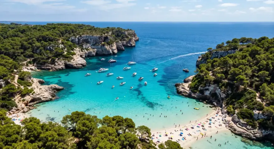 Vacker vik med turkost vatten, båtar och solande människor. En idyllisk plats där spanien vinter temperatur lockar besökare.