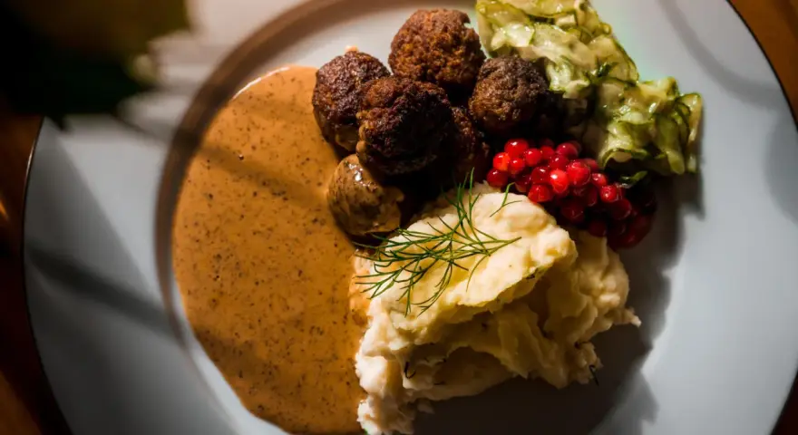 Klassiska svenska rätter: köttbullar med krämig sås, potatismos, lingon och pressgurka.