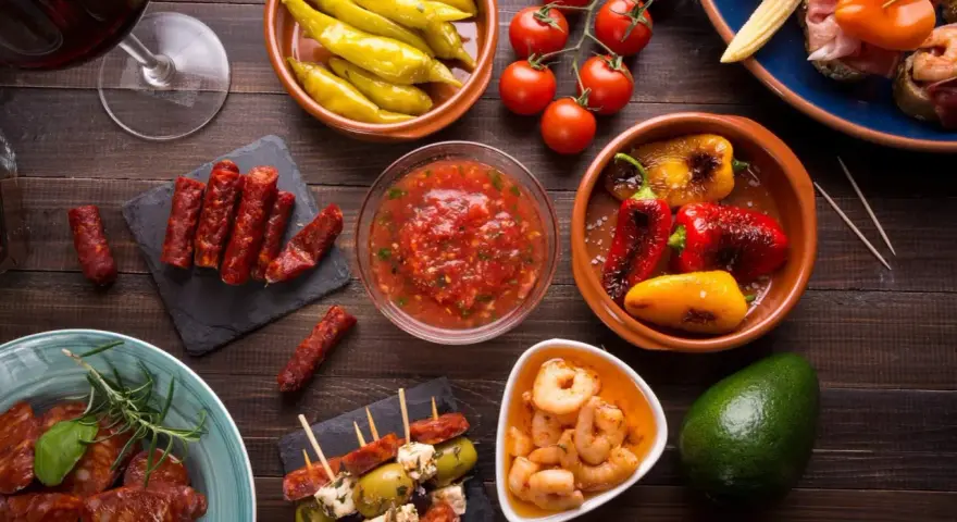 En härlig samling portugal mat: charkuterier, räkor, oliver, paprika och tomater, perfekt för en tapasbuffé.
