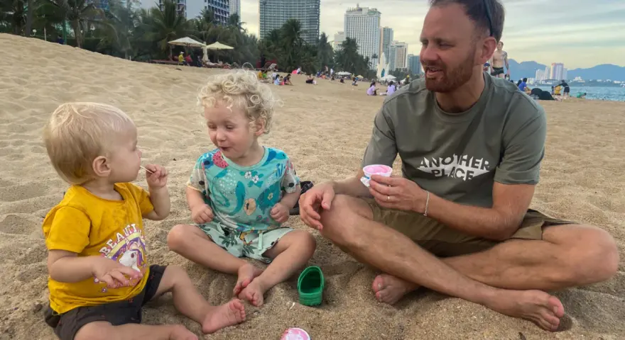 En familj njuter av glass på stranden. Undrar du vad kostar det att åka till Thailand 2 veckor?