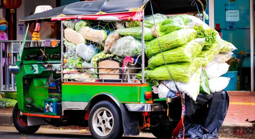 Grön tuk tuk thai lastad med grönsaker, redo för leverans.