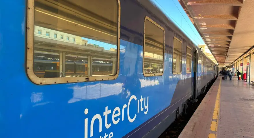 Blått InterCity-tåg står vid perrongen, redo för en resa till Sicilien.
