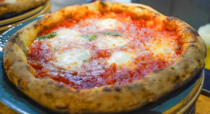 En härlig pizza florens med bubblig kant, röd tomatsås och smält mozzarella. Perfekt för en mysig kväll.