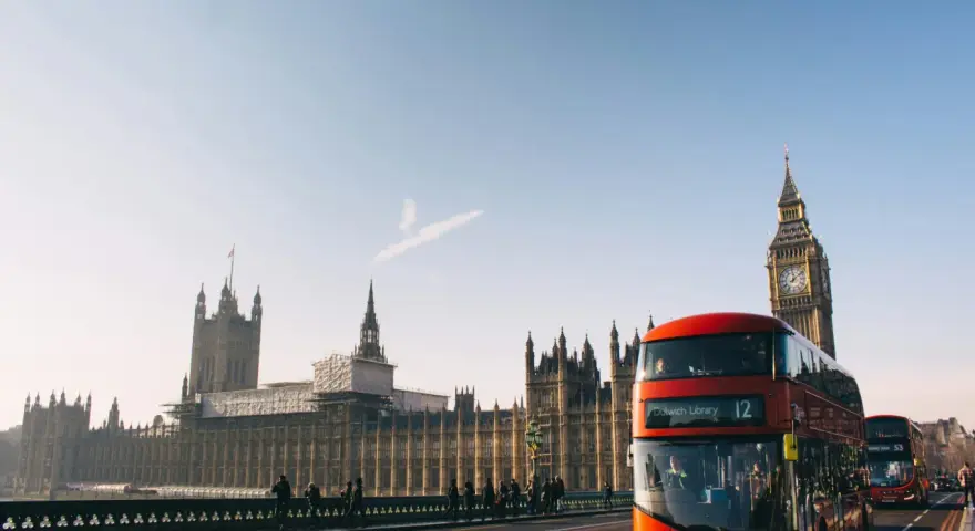 En röd dubbeldäckare passerar Big Ben och Houses of Parliament. En perfekt dag för en **turista i London**.