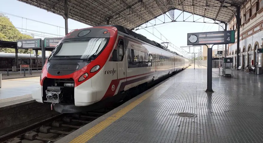 Ett modernt rött och vitt Renfe-tåg står redo på perrongen. Kanske är det dags för ett tåg till Spanien?