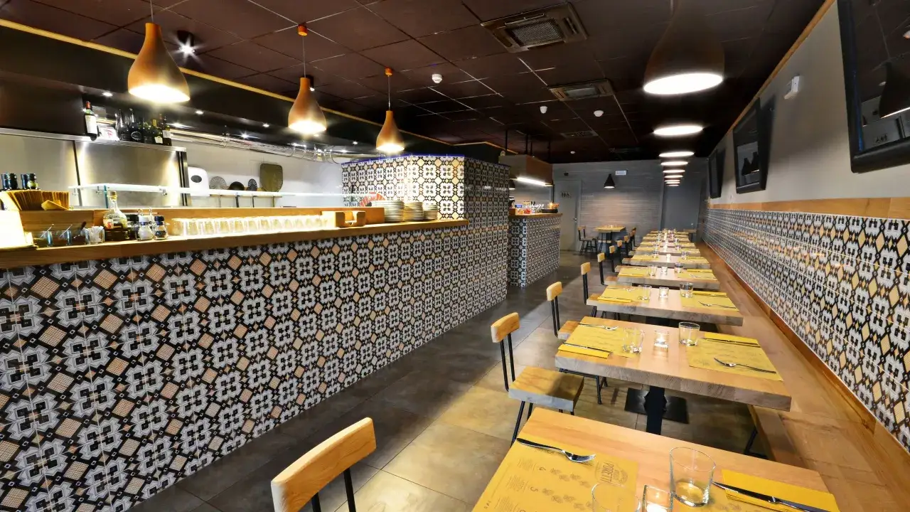 En restaurang med vackra kakelv&auml;ggar och tr&auml;bord, redo f&ouml;r g&auml;ster som vill njuta av en pizza florens.