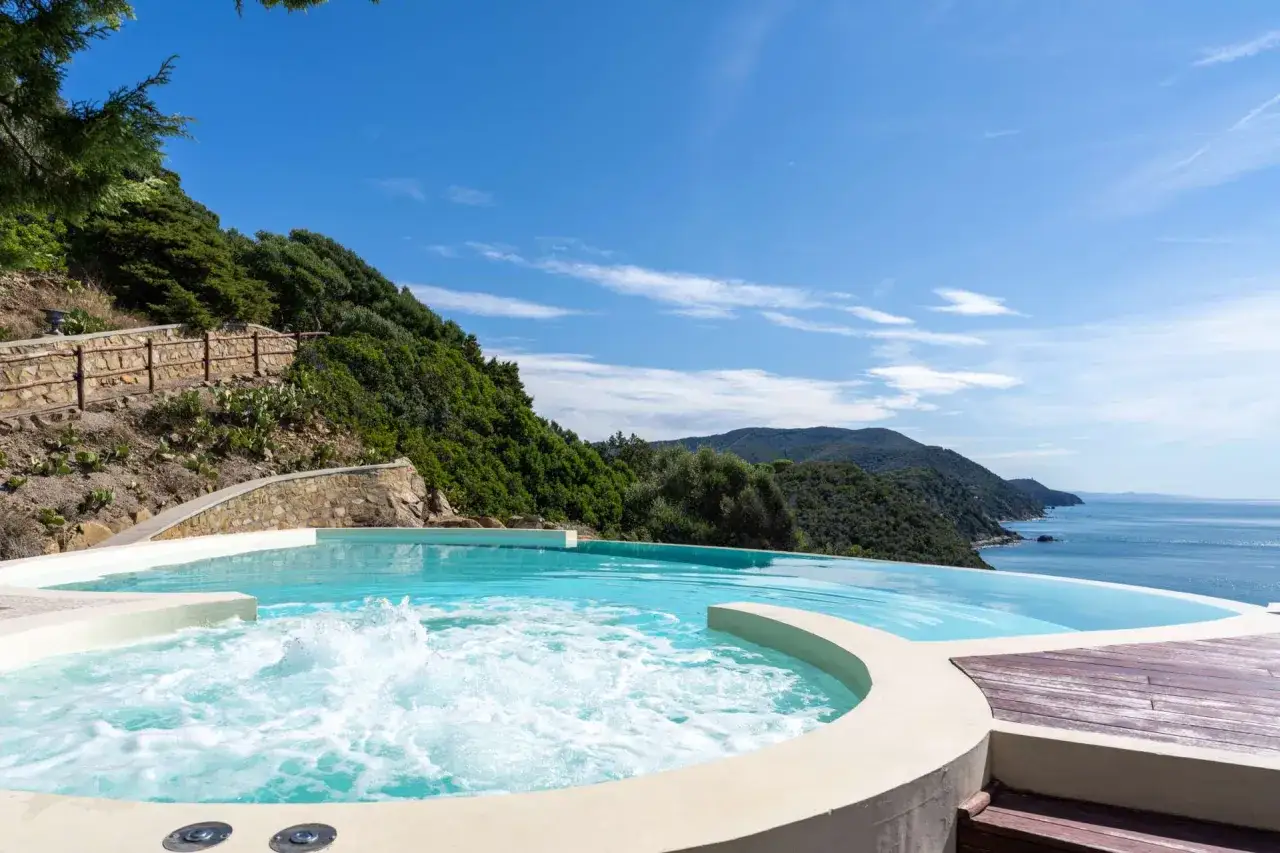 En bubblande jacuzzi och infinitypool med utsikt &ouml;ver havet, en dr&ouml;m f&ouml;r badorter i Toscana.