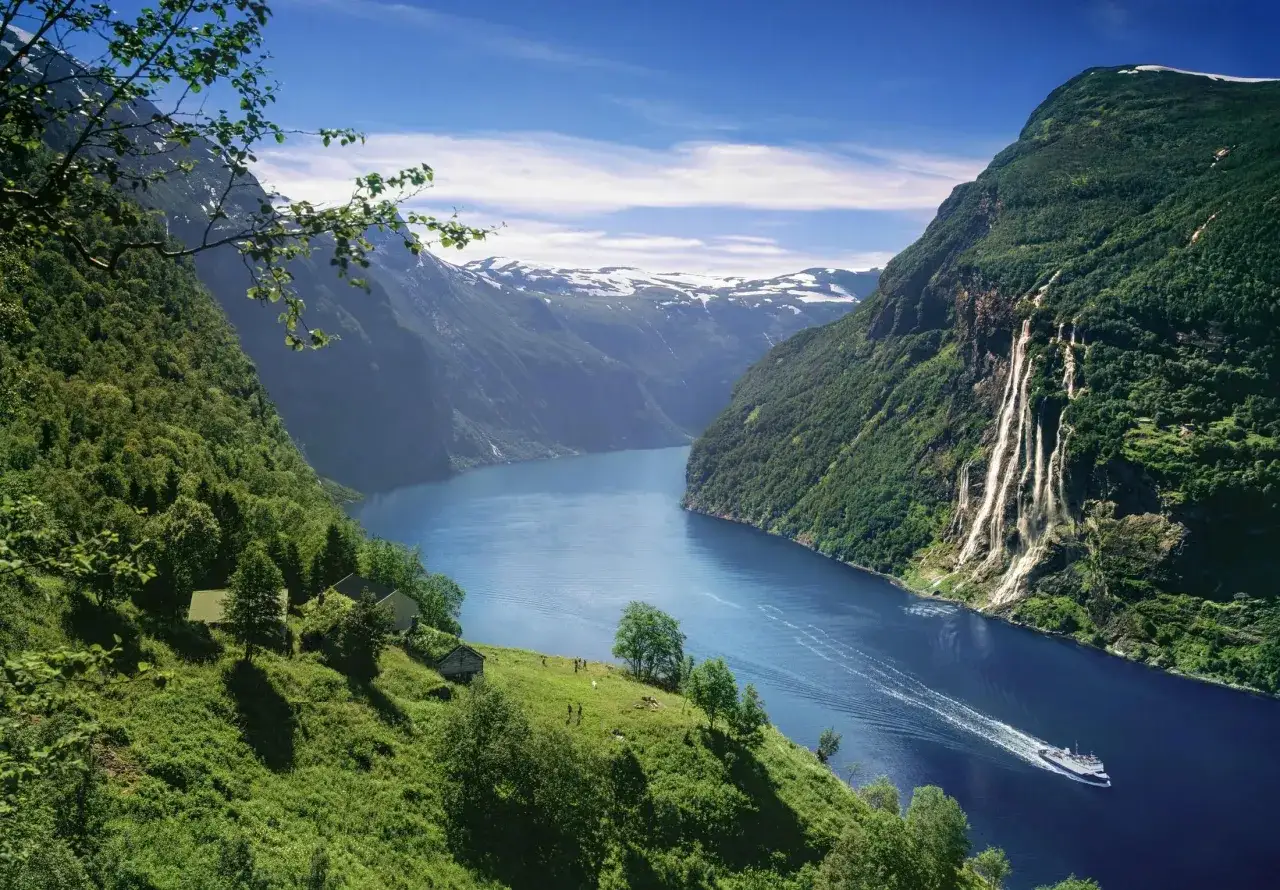 Majest&auml;tiska bergen i Norge bjuder p&aring; en hisnande natur. En b&aring;t glider fram p&aring; den djupbl&aring; fjorden, omgiven av gr&ouml;na sluttningar och vattenfall.